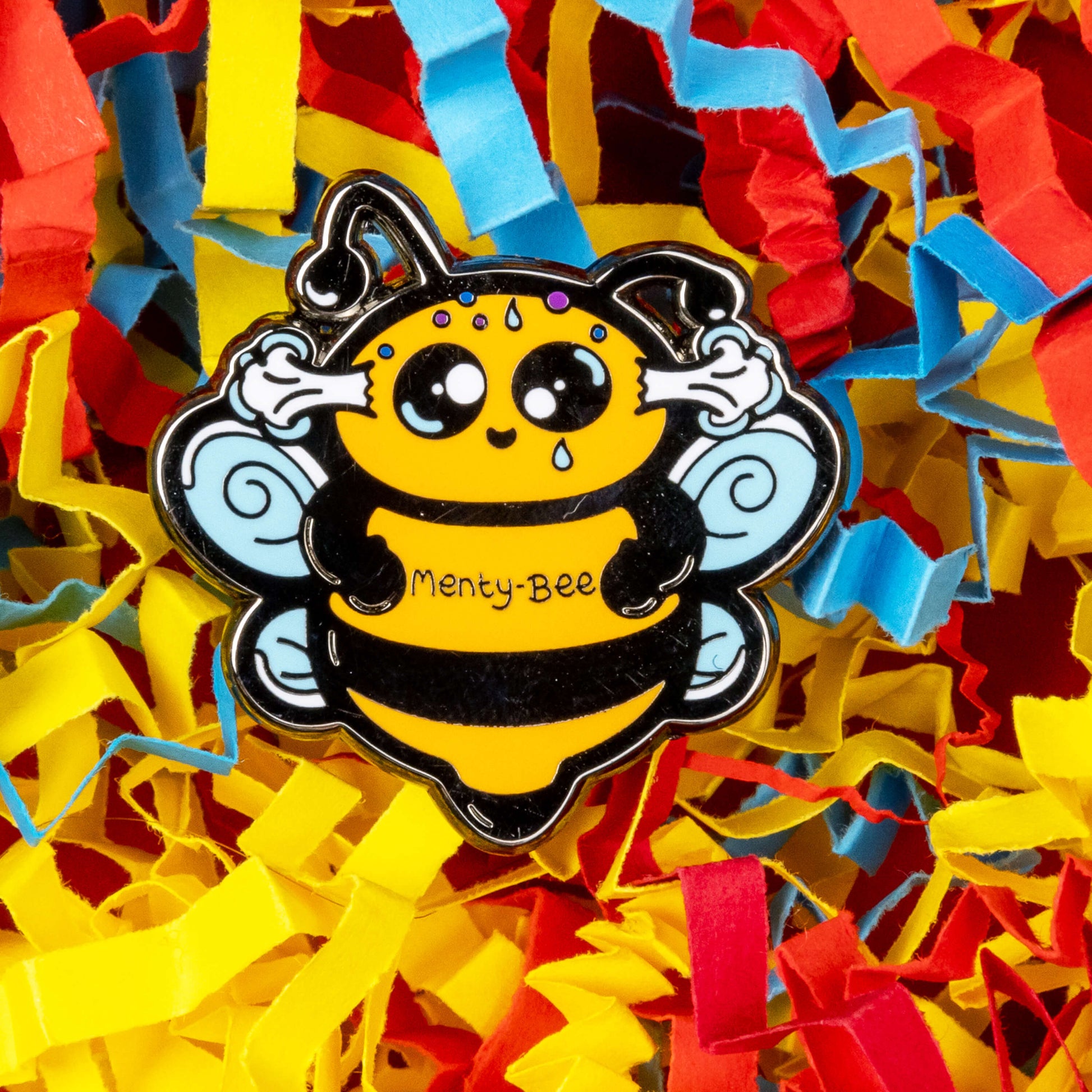 Menty-Bee Enamel Pin - Mental Breakdown on a card confetti background. The enamel pin is of a bee looking stressed with steam coming out of its head and the text menty-Bee on its chest. Hand drawn design made to raise awareness for mental breakdowns