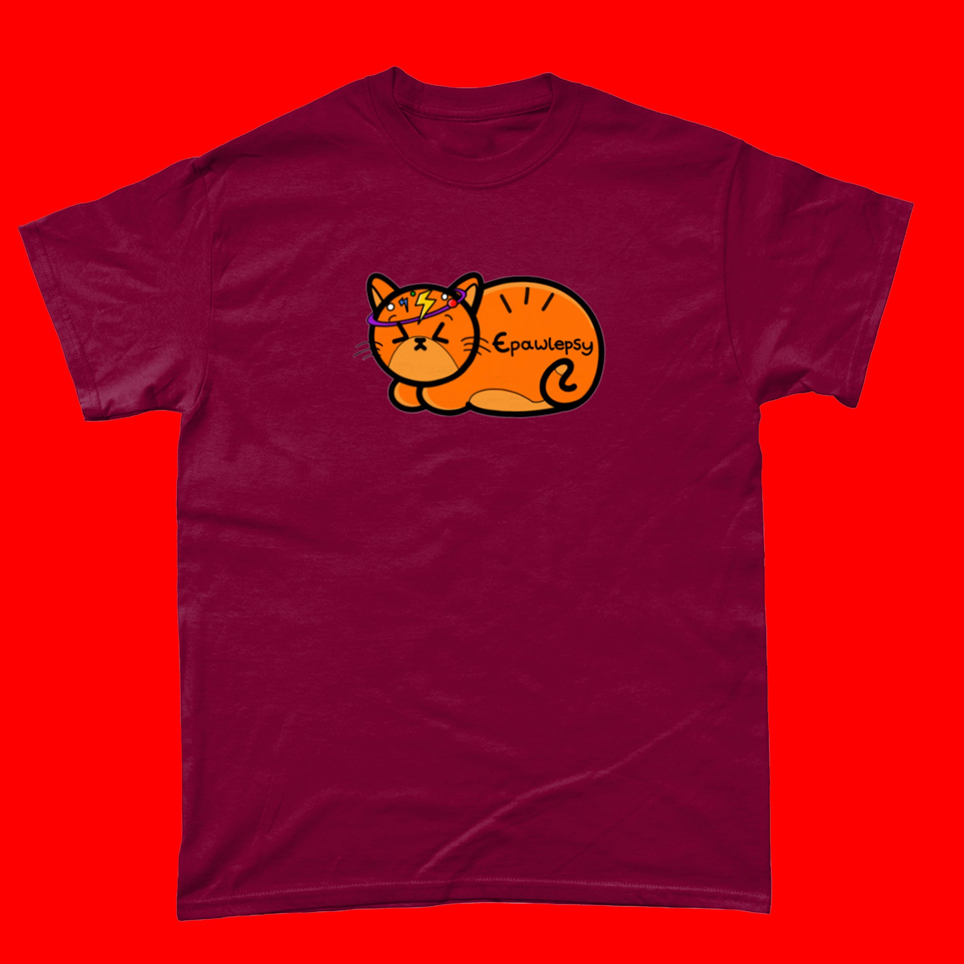 Epawlepsy Tee - Epilepsy. The cardinal red cotton t-shirt is a ginger cat with eyes scrunched closed and symbols to represent a dizzy spell drawn across his head. Epawlepsy is written on the cats stomach. Tee is designed to raise awareness for epilepsy