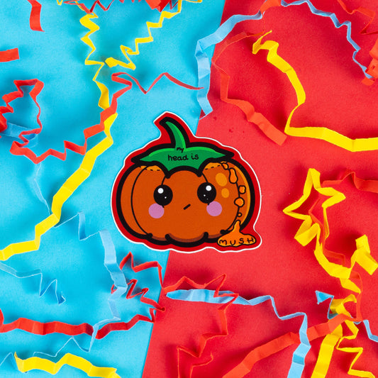 Innabox sticker featuring a cute pumpkin character with large, shiny eyes, blushing cheeks, and a humorous expression. The pumpkin has a small green stem with the text 'My head is mush' written above, adding a touch of relatability for anyone feeling mentally drained. Surrounded by vibrant red, blue, and yellow paper confetti, this playful design by Innabox offers a lighthearted take on mental exhaustion, perfect for those who appreciate quirky humour and self-care reminders.